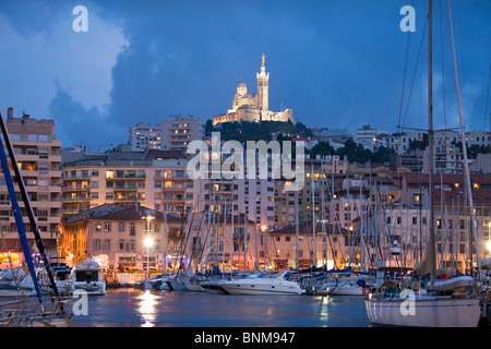 Frankreich Marseille Süd OfFrance Häuser Wohnungen Stadt Stadt alte Hafen Hafen Boote Yachten am Abend Kirche Notre Dame du Garde Stockfoto