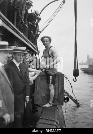 Entfesselungskünstler Harry Houdini (1874-1926) vorbereitet sein berühmtes "über Bord Box escape" zum ersten Mal im Juli 1912. Stockfoto