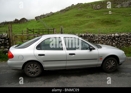 Auto auf einer Straße in der Nähe von einem trockenen Steinmauern in der Nähe von Malhamdale in Yorkshire Dales Stockfoto