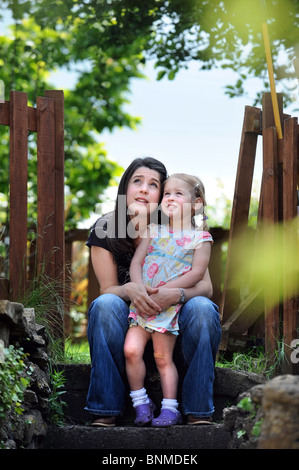 Ein junges Mädchen und ihre Mutter sitzt auf einem Garten Schritt UK Stockfoto