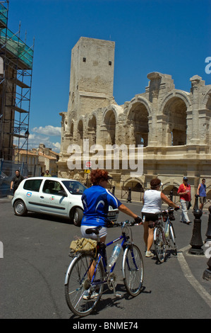 Arles, Frankreich - Straßenszene draußen, weibliche Touristen mit Fahrrädern, Besuch der römischen Arena, Frau, die auf der Straße fährt, Auto Stockfoto