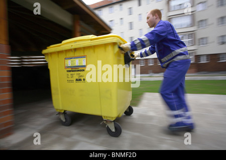Junge Praktikantin schob eine Mülltonne, Berlin, Deutschland Stockfoto