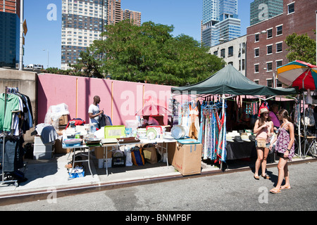 zwei hübsche Mädchen im Chat vor der Stände verkaufen recycelte & Spezialität Kleidung & Sonstiges auf Hells Kitchen Flea market Stockfoto