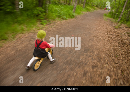 Drei Jahre altes Mädchen, die ihre hölzernen Fahrrad unterwegs zu Thunderbird Wasserfällen, Eklutna, Alaska Stockfoto