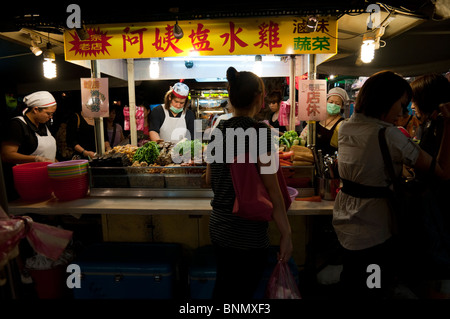 A shop Verkauf gegrilltes Gemüse und Fleisch lockt Kunden auf dem Shilin Nachtmarkt in Taipei. Stockfoto