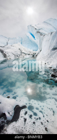 Sonne spiegelt sich in einem Pool von Gletscherwasser mit Eis Flossen auf dem Matanuska Gletscher, Alaska Stockfoto