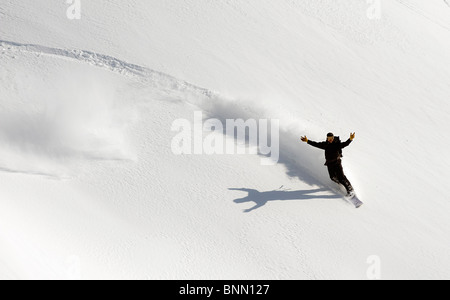 Ein Snowboarder wirft seine Arme in der Feier beim Snowboarden im Turnagain Pass Backcountry, Alaska Stockfoto