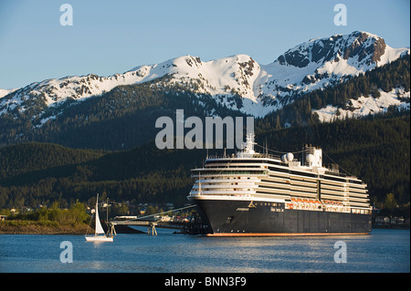 Ein Segelboot geht vor der angedockten Holland America Line Kreuzfahrt Schiff/n'Zuiderdam ' in Gastineau Channel, Juneau, Alaska Stockfoto