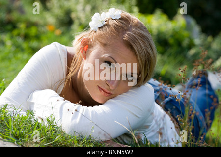 Junge Frau im Sommer Gras liegen. Stockfoto