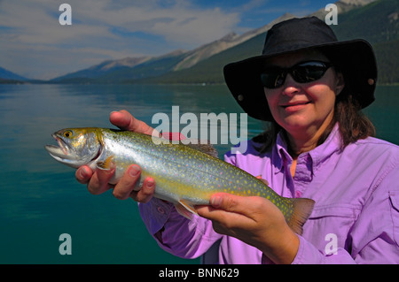 Ein Dame Angler hebt eine große Regenbogenforelle genommen auf Kanadas Maligne Lake im Jasper National Park (Rocky Mountains) Stockfoto