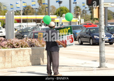 Human Billboard - A Mann hält ein Werbeschild an der Ecke der Chapman Avenue und Tustin in der Stadt Orange, CA. Stockfoto