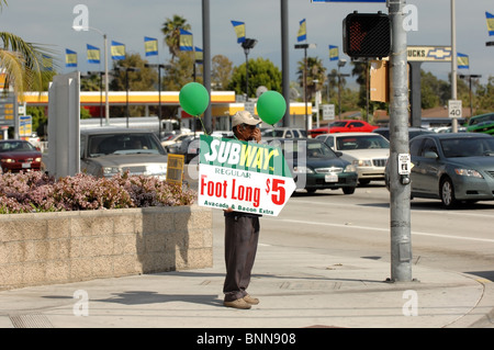 Human Billboard - A Mann hält ein Werbeschild an der Ecke der Chapman Avenue und Tustin in der Stadt Orange, CA. Stockfoto