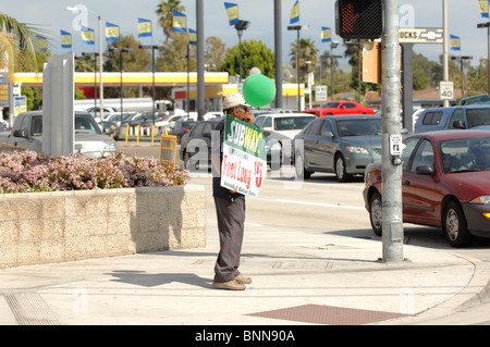 Human Billboard - A Mann hält ein Werbeschild an der Ecke der Chapman Avenue und Tustin in der Stadt Orange, CA. Stockfoto