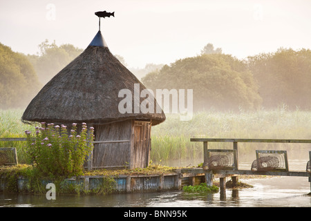 Tatched Fischerhütte und Aal fallen am River Test Longstock Hampshire UK Stockfoto