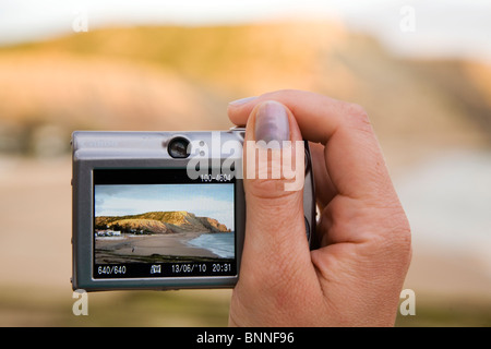 Eine weibliche Urlauber fotografiert ein Rocha Negra Klippen im Luz in Lagos an der Algarve Küste von Portugal. Stockfoto