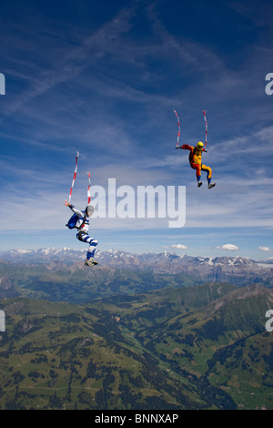 Fallschirmspringer sind Kopf fliegen innerhalb eines Teams in der Sit-fliegen-Position über eine spektakuläre Berglandschaft mit mehr als 120 km/h Geschwindigkeit. Stockfoto