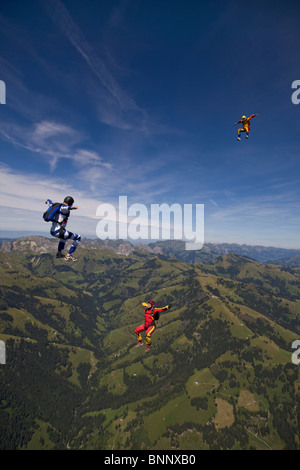 Fallschirmspringer sind Kopf fliegen innerhalb eines Teams in der Sit-fliegen-Position über eine spektakuläre Berglandschaft mit mehr als 120 km/h Geschwindigkeit. Stockfoto