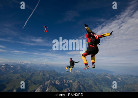 Fallschirmspringer sind Kopf fliegen innerhalb eines Teams in der Sit-fliegen-Position über eine spektakuläre Berglandschaft mit mehr als 120 km/h Geschwindigkeit. Stockfoto