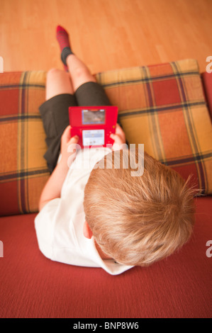 Ein MODEL-Release Nahaufnahme Bild eines sechsjährigen Jungen spielen auf einem Nintendo DS handheld Computer Spielkonsole im Vereinigten Königreich Stockfoto