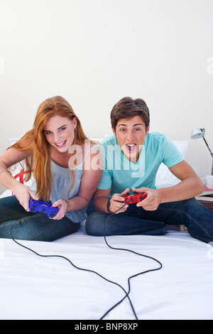 Ein aufgeregt Teen paar Spielen von Videospielen Stockfoto