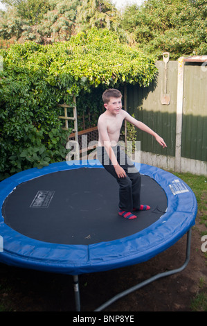 Ein MODEL Release zehnjähriger Junge springen auf einem Trampolin zeigen Bewegung in Großbritannien Stockfoto