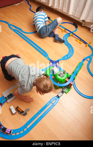 Ein Modell veröffentlicht Foto von zwei Jungs (6 & 10) spielen mit TOMY Thomas Tank engine Zug im Vereinigten Königreich Stockfoto