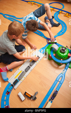 Ein Modell veröffentlicht Foto von zwei Jungs (6 & 10) spielen mit TOMY Thomas Tank engine Zug im Vereinigten Königreich Stockfoto