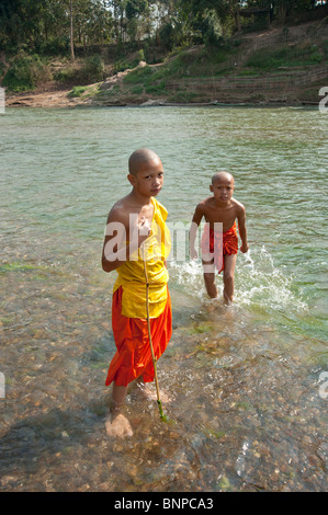 Junge Novizin buddhistische Mönche nehmen Sie ein Bad in einem nahe gelegenen Fluss in Luang Prabang Laos Stockfoto