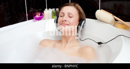 Entspannte Frau Musik hören in einem Schaumbad Stockfoto