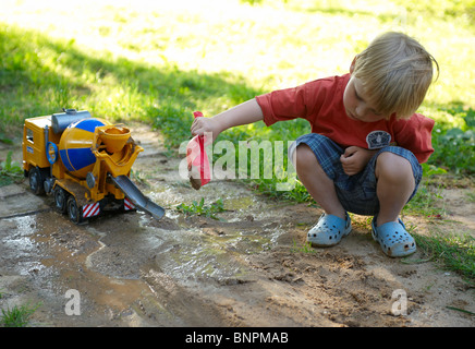 Kind junge Boys im Sand Grube spielen mit Spaten und Spielzeug Auto Autos Fahrzeug Spielplatz 2-3-4 Jahre Stockfoto