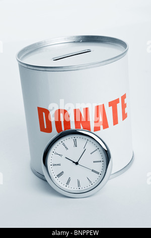 Spendenbox und Uhr, Konzept von "Zeit zu spenden" oder "Spenden Ihre Zeit". Stockfoto