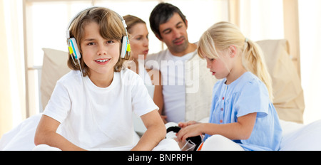 Lächelnde Geschwister Musik mit Kopfhörern hören Stockfoto