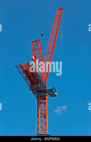 Roter Turmdrehkran gegen blauen Himmel - eine Nahaufnahme. Stockfoto