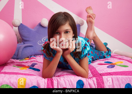 Junges Mädchen auf ihr Bett tragen ihre Pyjamas Stockfoto