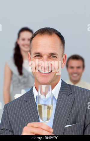 Erfolgreicher Geschäftsmann hält Champagner mit seinem team Stockfoto