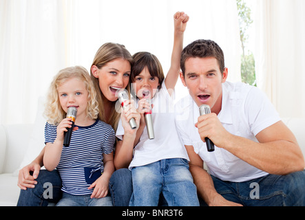 Porträt von einer lebhaften Familie singen über Mikrofon Stockfoto