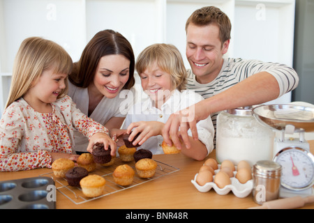 Liebevolle Familie, die ihre Muffins Essen Stockfoto