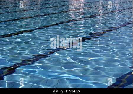 SUN SHNING UND REFLEKTIEREN DIE WELLEN IM WASSER AUF DIE GASSEN VON EINEN AUSSENPOOL IN SPANIEN Stockfoto