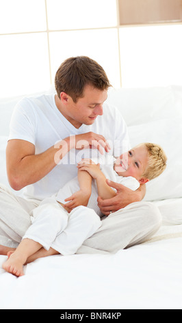 Animierte Vater und seinem kleinen Jungen spielen auf einem Bett Stockfoto