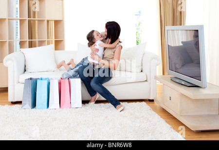 Glückliche Mutter und ihre Tochter zu Hause nach dem Einkauf Stockfoto