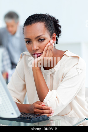 Gelangweilte Geschäftsfrau an ihrem Schreibtisch Stockfoto