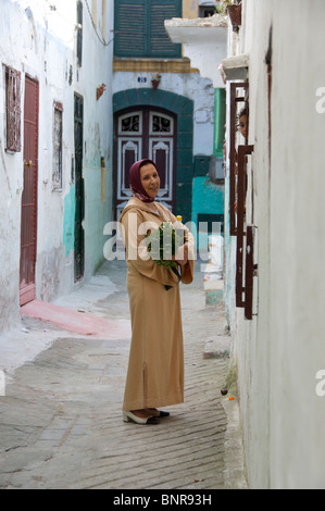 Marokko, Tetouan. Die Medina (Altstadt) von Tétouan, UNESCO. Frau in traditioneller Kleidung in typischen schmalen Gasse. Stockfoto