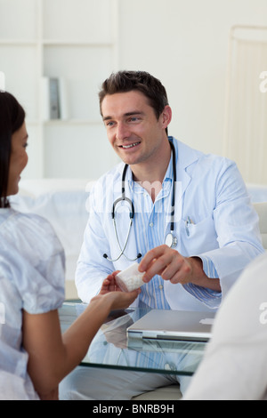 Männlichen Arzt einer Patientin Pillen geben Stockfoto