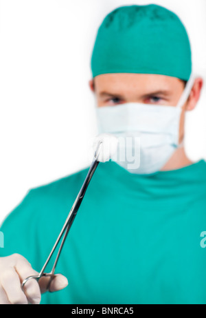 Charismatische männliche Chirurgen halten chirurgische Pinzetten Stockfoto