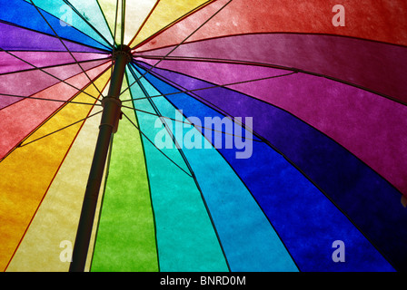 Regenbogen farbige Sonnenschirme am Strand gegen klaren blauen Himmel. Stockfoto