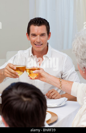 Attraktiver Mann mit seiner Mutter in einem Abendessen Toasten Stockfoto