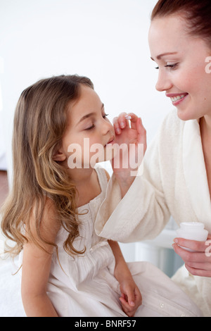 Mutter ihre Tochter Gesicht Creme aufsetzen Stockfoto