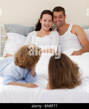 Brüder und Eltern im Bett liegend Stockfoto