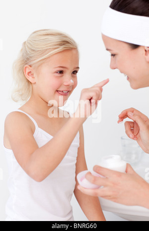 Mutter und Tochter Creme auf Gesicht setzen Stockfoto