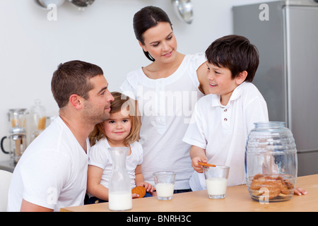 Eltern und Kinder essen Kekse und Milch trinken Stockfoto